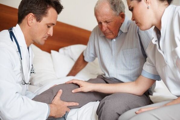 A doctor examines the patient's knee